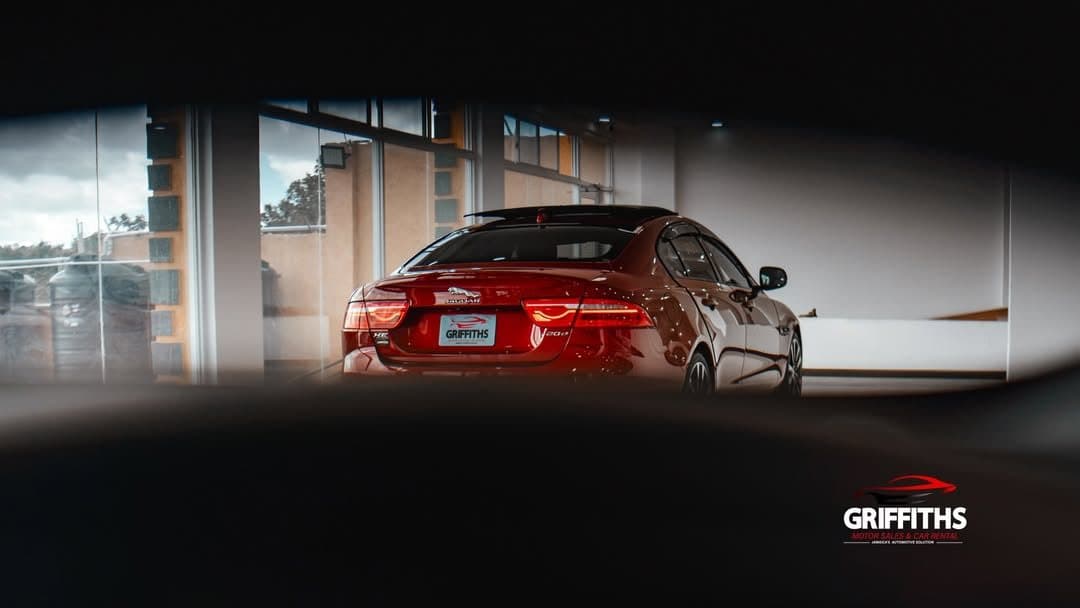 Red Jaguar seen through the Griffiths Motor Sales showroom window